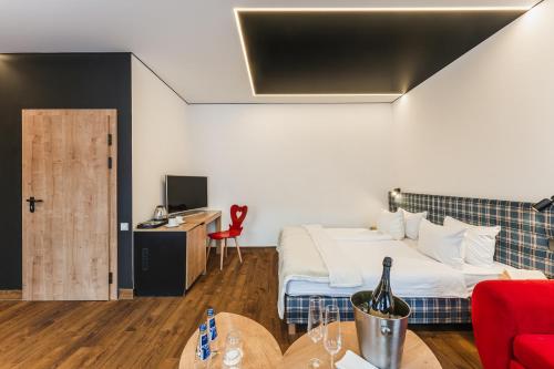 a hotel room with a bed and a desk with a bottle of wine at Szczawnica Park Resort & Spa in Szczawnica