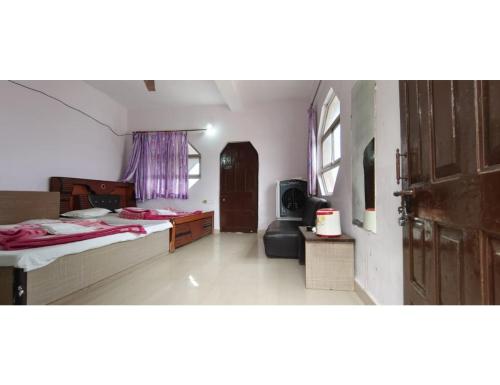 a large room with two beds and a door at Hotel Banjara, Pachmarhi in Pachmarhī