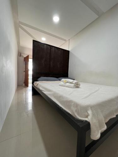 um quarto com uma cama grande e lençóis brancos em GCASH - Taal cozy private homestay with PRIVATE attached bathroom in General Trias - Pink Room em General Trias