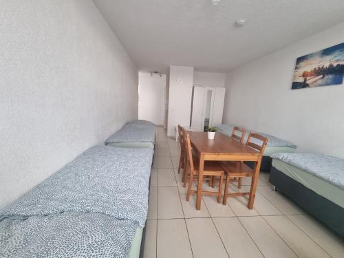 a room with two beds and a table and chairs at Workers-Sleep-Station in Cologne