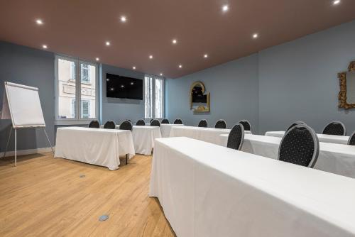 トゥーロンにあるGrand Hôtel Dauphiné, Boutique Hôtel & Suitesの白いテーブルと椅子、白いボードが備わる客室です。