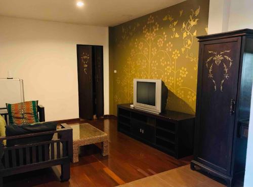 Thapae Boutique House في شيانغ ماي: غرفة معيشة مع تلفزيون وأريكة