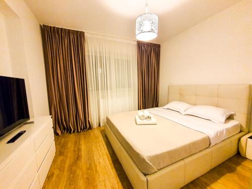 um quarto com uma cama e uma televisão de ecrã plano em Luxurious Retreat 1BR Apartment with Netflix, Private Parking and self check in em Popeşti-Leordeni