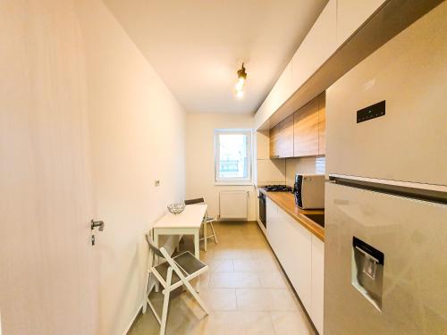 uma pequena cozinha com uma mesa e um frigorífico em Luxurious Retreat 1BR Apartment with Netflix, Private Parking and self check in em Popeşti-Leordeni