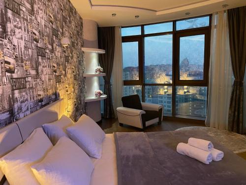 a bedroom with a large bed with a large window at Meqafun Sea View apartment in Baku