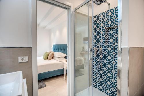 uma casa de banho com uma cabina de duche em vidro e uma cama. em Villa Francesca - private pool em Sorrento