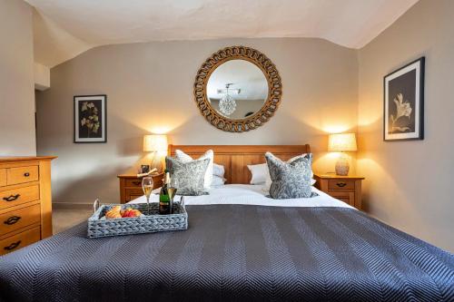 a bedroom with a large bed and a mirror at Finest Retreats - Ivy Cottage in Casterton