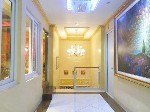 un corridoio con un grande dipinto sul muro e un lampadario a braccio di MY HOME @BALI HOTEL BY CONARY a Kuta