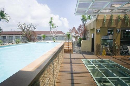 a swimming pool in front of a house at MY HOME @BALI HOTEL BY CONARY in Kuta