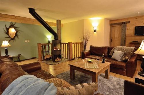 a living room with a couch and a fireplace at Black Diamond Sainte Foy Chalets in Sainte-Foy-Tarentaise