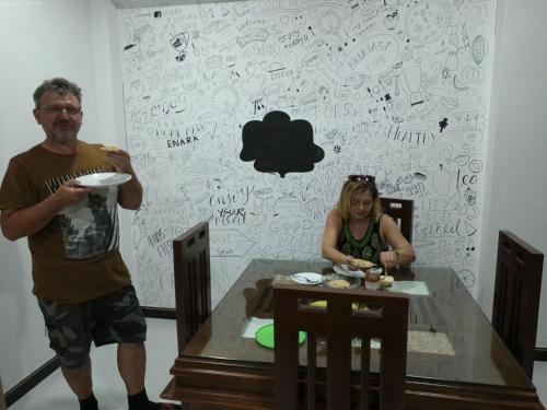 a man and a woman sitting at a table with a plate at Enara Luxury Stay in Katugastota