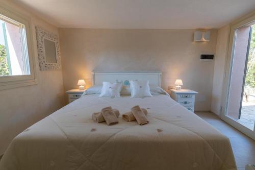 a bedroom with a large white bed with towels on it at VILLA AMIRA Porto Cervo con vista Mozzafiato sul Mare,Piscina Privata,WELLNESS & SPA in Liscia di Vacca