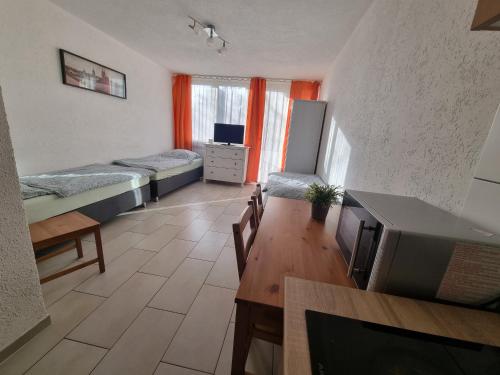 a room with three beds and a table and a tv at Workers-Sleep-Station in Cologne