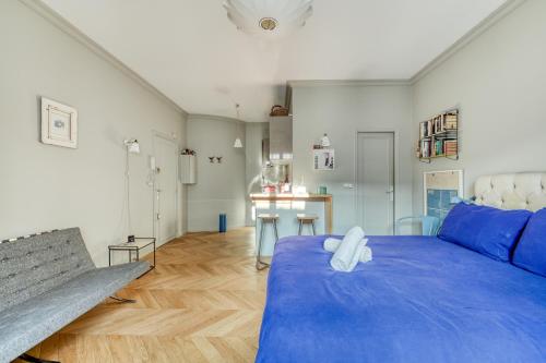 - une chambre avec un grand lit bleu et un banc dans l'établissement Perfect Parisian Apartment LeMarais for you!, à Paris