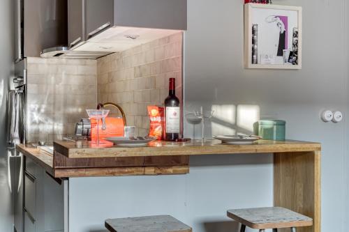 a kitchen with a counter with a bottle of wine at Perfect Parisian Apartment LeMarais for you! in Paris