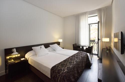 a hotel room with a large bed and a window at Hospes Palau de La Mar in Valencia