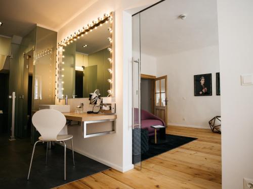 Zimmer mit einem Waschtisch und einem Schreibtisch mit einem Spiegel in der Unterkunft artHotel Blaue Gans in Salzburg
