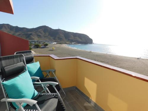 2 sillas en un balcón con vistas a la playa en PERLA Penthouse, en Gran Tarajal