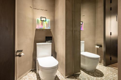 a bathroom with two toilets in a room at NOA Hotel SHENZHEN LUOHU in Shenzhen