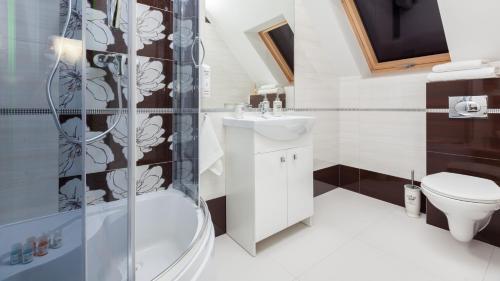 ein Bad mit einer Dusche, einem WC und einem Waschbecken in der Unterkunft Willa Marcella in Białystok
