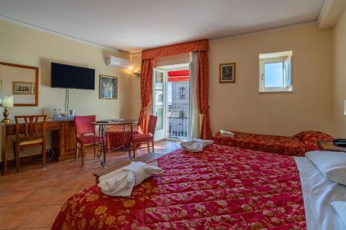 a hotel room with a bed and a table and chairs at Hotel Mediterraneo in Siracusa