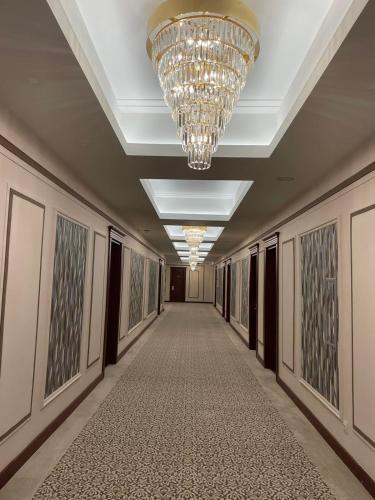 a hallway with a chandelier and a long corridor at Ramada by Wyndham Plovdiv Trimontium in Plovdiv