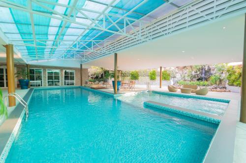 a large swimming pool with a blue ceiling at Rimkhobfa Urban Resort in Samutprakarn