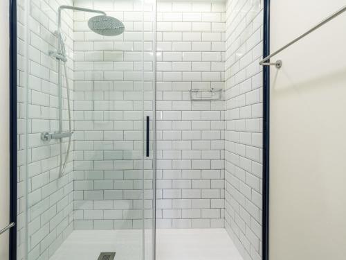 a glass shower with white subway tiles in a bathroom at Holi-Rent Penthouse Peñuelas in Seville