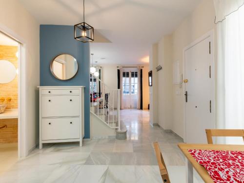 a dining room with blue walls and a table and a mirror at Holi-Rent Penthouse Peñuelas in Seville