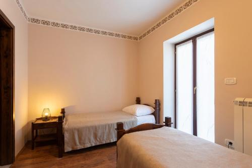a bedroom with two beds and a window at Guest House Valentincic in Nova Gorica