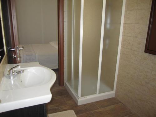 ein Badezimmer mit Dusche, Waschbecken und Toilette in der Unterkunft agriturismo gli olivastri, appartamento la rosa dei venti con piscina e solarium , vista mare ,climatizzatore ,wifi in Aglientu