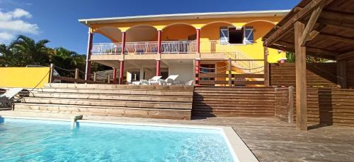 una casa con piscina frente a una casa en Villa CosaRoé Martinique Piscine et superbe vue mer en Rivière-Salée