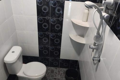 a bathroom with a toilet and black and white tiles at Azhar Homestay in Jitra