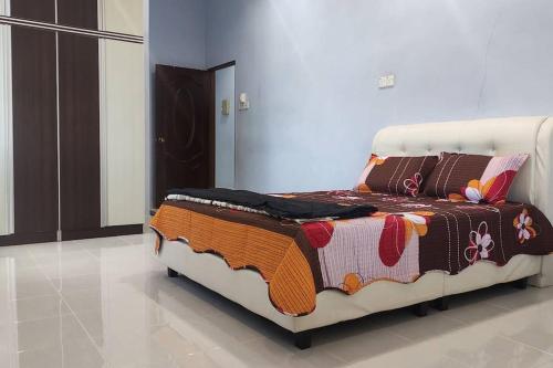 a bed with a blanket on it in a room at Azhar Homestay in Jitra
