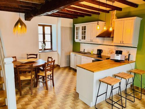 a kitchen with a table and a table and chairs at Les Villas du Domaine de Suzel in Vignieu