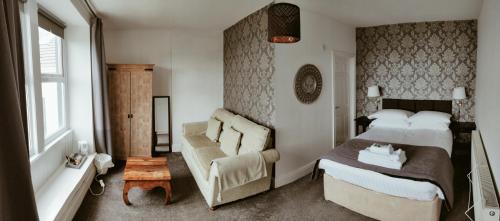 um quarto com uma cama, um sofá e uma cadeira em The Mansion em Whitehaven