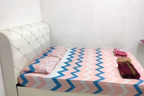 ein Schlafzimmer mit einem Bett mit einem Koffer drauf in der Unterkunft D'Haja 5 KLIA Sepang with Free Wi-Fi & 3 Airconds in Banting