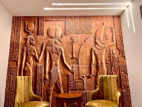 a wall mural in a room with two chairs at New Museum Guest House, Pyramids View in Cairo