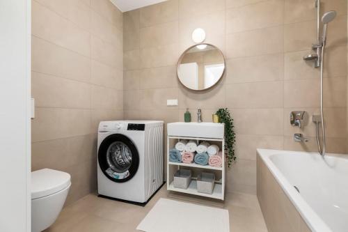 ウィーンにあるDesign apartment with amazing view over Viennaのトイレの隣に洗濯機が付いたバスルームがあります。