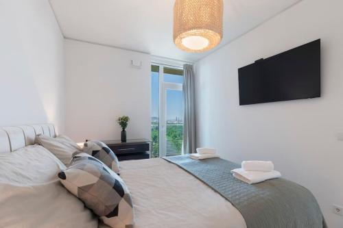 a bedroom with a large bed with a flat screen tv at Design apartment with amazing view over Vienna in Vienna