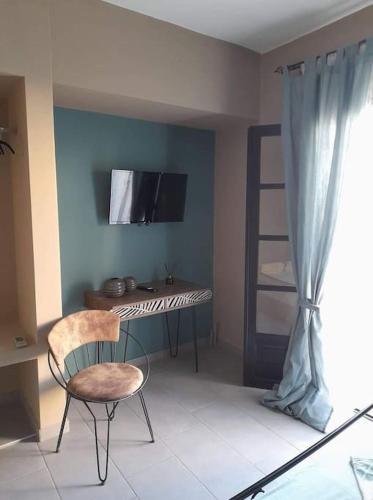 a room with a desk and a chair and a television at Διαμέρισμα με θέα θάλασσα στην περιοχή της Αθύτου in Afitos