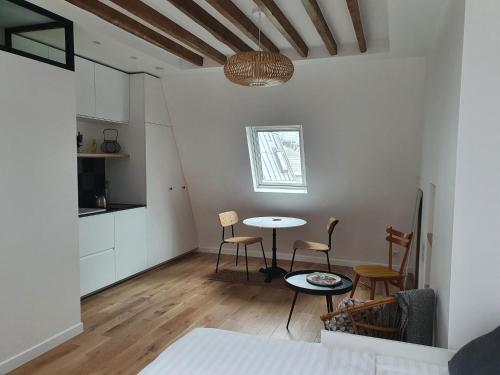 une cuisine et un salon avec une table et des chaises dans l'établissement Chambre d'hôtes confort et charme Paris 9eme, à Paris