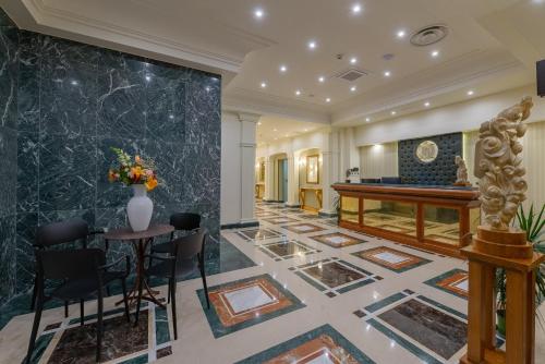 a lobby with a piano and a table at La Paloma Blanca Hotel in Sciacca