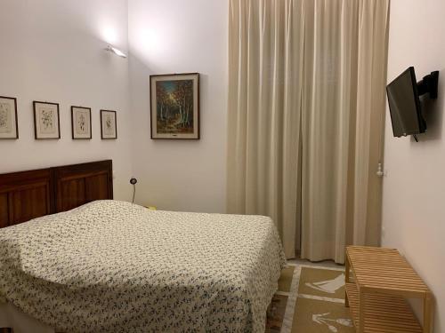 a bedroom with a bed and a flat screen tv at B&B Viale Italia 22 in Follonica