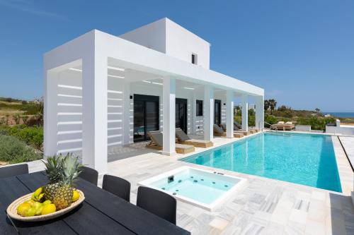 a villa with a swimming pool and a table with fruit at Seastar Villa, Lachania Beach in Lachania