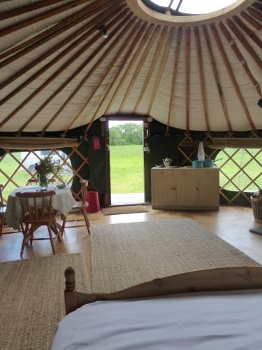 FernhurstにあるChestnut Yurtのベッドとパオのテーブルが備わる部屋