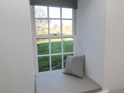 un asiento junto a la ventana con una almohada delante en Flodden en Cornhill-on-tweed