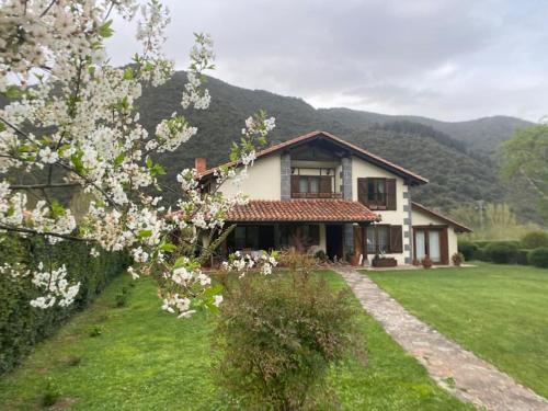 a house with a flowering tree in the yard at Excepcional Casa El Olivo in Ojedo