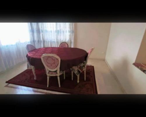 a purple table and chairs in a room with a window at Bel appart au cœur de Casablanca in Casablanca