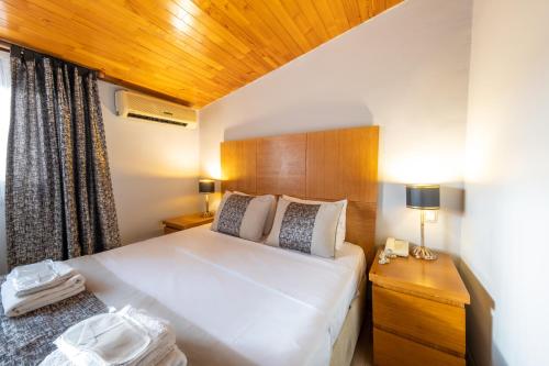 a bedroom with a large white bed and a wooden ceiling at King Suites Beşiktaş in Istanbul